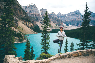 Woman practising yoga, Moraine Lake, Banff, Canada - ISF21098