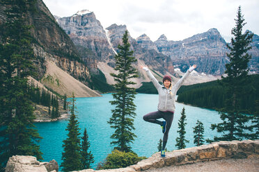 Woman practising yoga, Moraine Lake, Banff, Canada - ISF21099