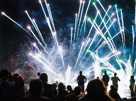 Gruppe von Menschen beobachten Feuerwerk in der Nacht - CUF50294