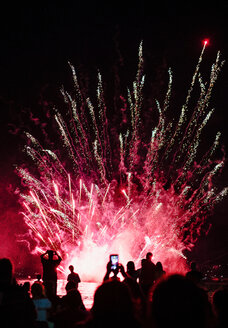 Gruppe von Menschen beobachten Feuerwerk in der Nacht - CUF50295