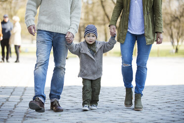 Porträt eines Jungen, der Hand in Hand mit seinen Eltern geht - MAEF12835