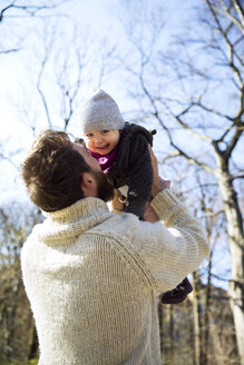 Vater hebt glückliche Tochter im Park hoch - MAEF12848