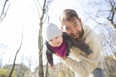 Portrait of happy father holding daughter in park - MAEF12851
