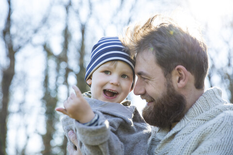 Happy father carrying son in park stock photo