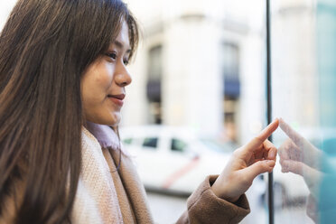 Spain, Madrid, young woman looking at the map and exploring the city - WPEF01461