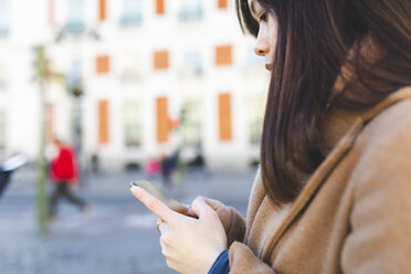 Spanien, Madrid, Nahaufnahme einer jungen Frau, die ihr Smartphone in der Stadt benutzt - WPEF01467