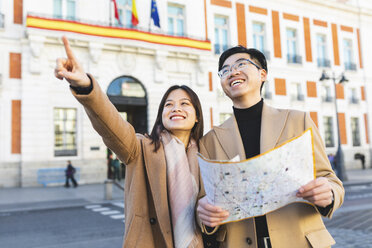 Spain, Madrid, happy young couple with map exploring the city - WPEF01476