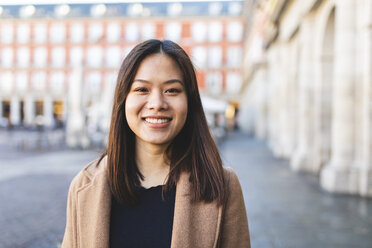Spain, Madrid, portrait of smiling young woman at Plaza Mayor - WPEF01482