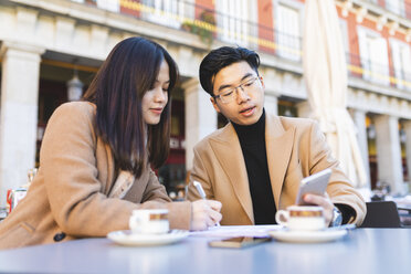 Spanien, Madrid, junges Paar benutzt Handy und macht sich Notizen in einem Café am Plaza Mayor - WPEF01489