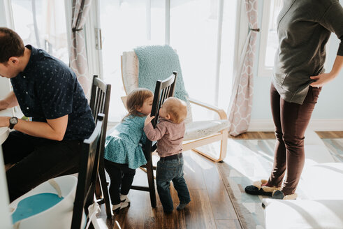 Baby-Junge und Kleinkind Schwester spielen im Wohnzimmer mit Mutter und Vater - ISF21232