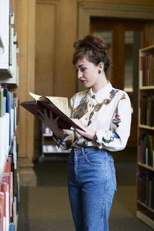 Studentin beim Lesen eines Buches in einer öffentlichen Bibliothek - IGGF01029