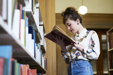 Studentin beim Lesen eines Buches in einer öffentlichen Bibliothek - IGGF01030