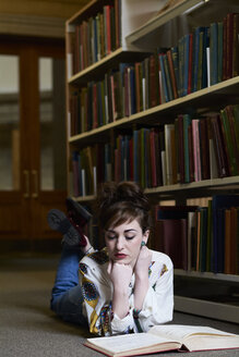 Studentin beim Lesen eines Buches in einer öffentlichen Bibliothek - IGGF01038