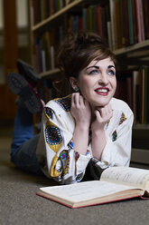 Female student reading a music book in a public library - IGGF01040