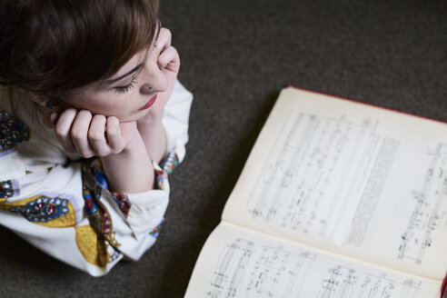 Studentin liest ein Musikbuch in einer öffentlichen Bibliothek - IGGF01041