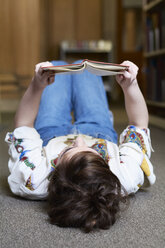 Studentin beim Lesen eines Buches in einer öffentlichen Bibliothek - IGGF01048