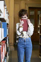 Studentin beim Lesen eines Buches in einer öffentlichen Bibliothek - IGGF01053