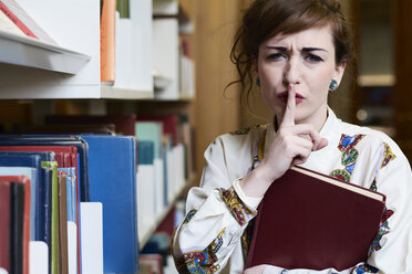 Studentin beim Lesen eines Buches in einer öffentlichen Bibliothek - IGGF01055