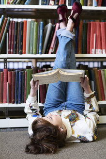 Studentin beim Lesen eines Buches in einer öffentlichen Bibliothek - IGGF01058