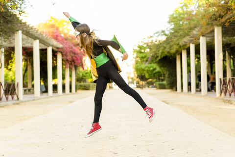 Girl in super heroine costume jumping stock photo