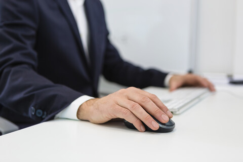 Close-up of businessman using computer at desk in office stock photo