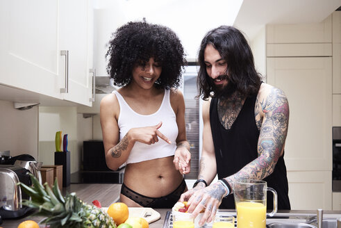 Glückliches junges Paar bei der Zubereitung einer gesunden Mahlzeit in der Küche - IGGF01084