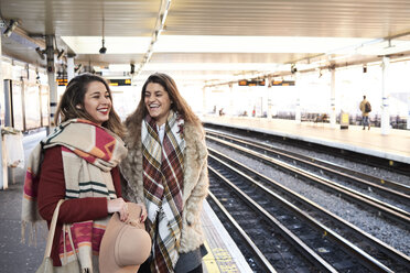 UK, London, zwei glückliche Frauen auf dem Bahnsteig einer U-Bahn-Station - IGGF01105