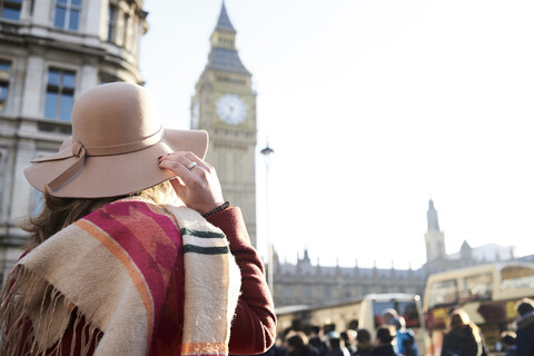 Großbritannien, London, Rückansicht einer Frau mit Schlapphut, die auf den Big Ben blickt, lizenzfreies Stockfoto