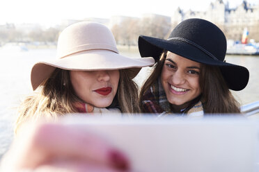 UK, London, zwei Frauen mit Schlapphüten machen ein Selfie auf der Millennium Bridge - IGGF01136