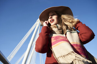 UK, London, stylish young woman talking on cell phone on Millennium Bridge - IGGF01141