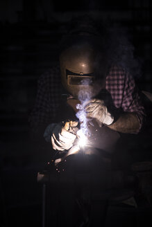 Mann schweißt in seiner Werkstatt - ABZF02316