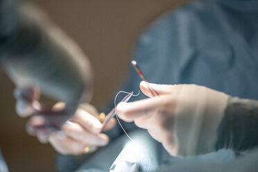 Doctors sewing a wound from an ankle operation in hospital - OCMF00391