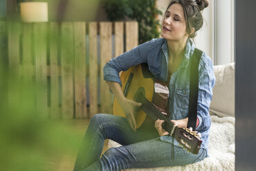 Passionate woman playing guitar at home - UUF17207