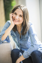 Portrait of happy woman wearing denim shirt at home - UUF17235