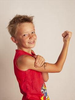 Porträt eines Jungen, der seine Muskeln anspannt - WWF05047