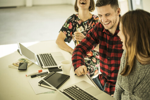 Kollegen sitzen im Büro, arbeiten zusammen, haben Spaß - MJRF00163