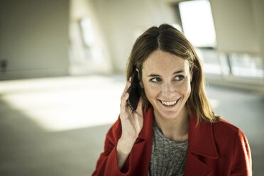 Businesswoman talking on the phone in new office rooms - MJRF00168