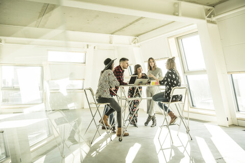 Group of creative professionals having a meeting in a bright office, discussing new solutions stock photo