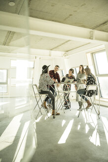 Eine Gruppe von Kreativprofis trifft sich in einem hellen Büro und bespricht neue Lösungen - MJRF00183