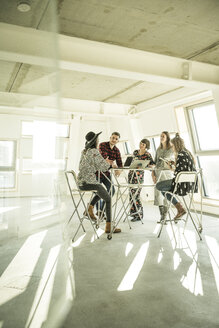 Group of creative professionals having a meeting in a bright office, discussing new solutions - MJRF00183