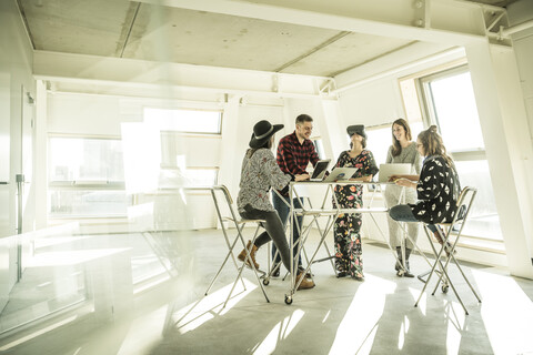 Group of creative professionals having a meeting in a bright office, discussing new solutions stock photo