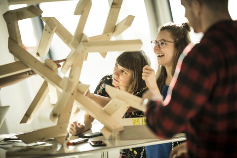 Group of creative professionals building wood object for a project stock photo