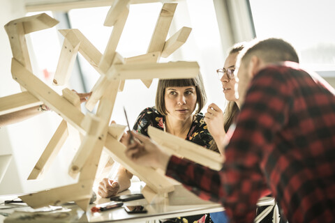 Group of creative professionals building wood object for a project stock photo