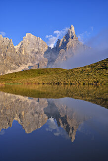 Italien, Trentino, Dolomiten, Passo Rolle, Gebirgskette Pale di San Martino, Cimon della Pala mit Baita Segantini, die sich in einem kleinen See spiegelt - RUEF02155