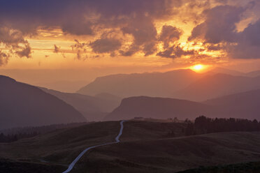 Italy, Dolomites, Passo Rolle, dirt road in the mountains at sunset - RUEF02163