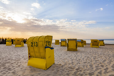 Germany, Lower Saxony, Cuxhaven, Duhnen, beach with hooded beach chairs at sunrise - WDF05241