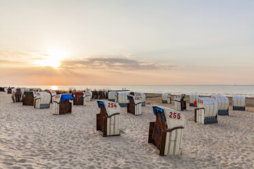 Germany, Lower Saxony, Cuxhaven, Duhnen, beach with hooded beach chairs at sunrise - WDF05243