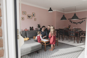Zwei Mädchen spielen mit ihren Großeltern im heimischen Wohnzimmer - KMKF00823