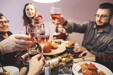 Familie beim gemeinsamen Abendessen stößt mit Weingläsern an - KMKF00828