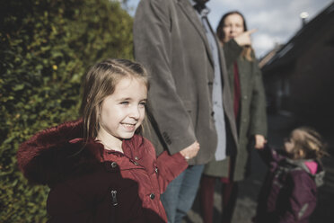 Smiling girl holding hand of her father outdoors - KMKF00835